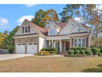 Charming two-story home featuring brick and siding, a two-car garage, and manicured landscaping at 1312 Golden Bluff Ln, Fuquay Varina, NC 27526