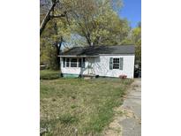 Charming single-story home with vinyl siding, a dark roof, and manicured lawn at 141 N Bullock St, Henderson, NC 27536