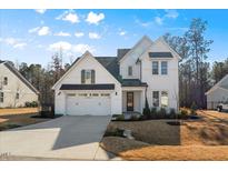 Charming two-story home featuring a pristine white facade, a two-car garage, and a neatly landscaped front yard at 201 W Amber Oak Drive, Selma, NC 27576