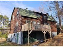 Rustic log cabin with a large deck overlooking the yard, offering a unique and charming living space at 207 High House Rd, Cary, NC 27513