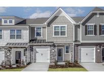 Charming townhome featuring a stone and shingle facade, attached garages, and neatly landscaped front yards at 2118 Willow Gln Dr, Graham, NC 27253