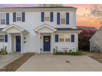 Charming two-story townhouse featuring white siding, navy shutters, and a well-maintained front yard at 2225 Whistling Straits Way, Raleigh, NC 27604