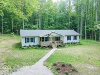 Charming single-story home boasts a welcoming front porch and a well-maintained yard surrounded by lush trees at 3014 Split Wood Ct, Oxford, NC 27565