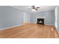 Bright living room with hardwood floors, fireplace and ceiling fan at 302 Rushingwater Dr, Cary, NC 27513