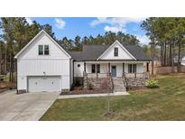Charming two-story home boasts a light blue front door, covered porch and a manicured lawn at 381 Heart Pine Dr, Wendell, NC 27591