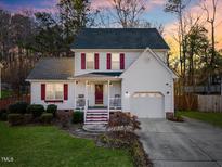 Charming two-story home with red shutters, inviting front porch, and attached garage, perfect for suburban living at 409 Machost Dr, Garner, NC 27529