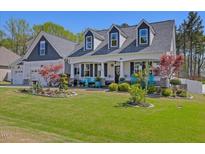 Charming two-story home with a inviting front porch and well-manicured lawn at 49 Everwood Dr, Four Oaks, NC 27524