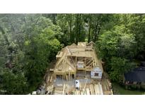 Framing underway on a new construction home surrounded by mature trees at 5205 Quail Meadows Dr, Raleigh, NC 27609