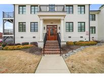 Inviting condominium exterior featuring a brick stairway, elegant pillars and a warm wooden door at 605 Smedes Pl # A, Raleigh, NC 27605