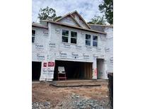 Unfinished townhome exterior featuring the front entrance and a two-car garage under construction at 6962 Doddridge Ln # 14, Cary, NC 27519