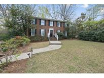 Charming brick home featuring a manicured lawn and inviting front entrance with classic black shutters and white trim at 721 Blenheim Dr, Raleigh, NC 27612