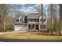 Charming two-story home with a two-car garage, dark shutters, and manicured landscaping at 765 Carlton St, Clayton, NC 27520