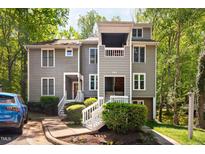 Inviting two-story condo features a well-manicured lawn, lush landscaping, and a charming covered porch at 101 Hunting Chase # 2B, Cary, NC 27513
