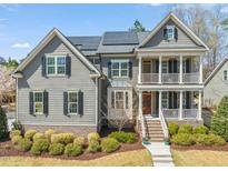 Two-story home with gray siding, solar panels, black shutters, and manicured landscaping at 113 Bennett Mountain Trce, Chapel Hill, NC 27516