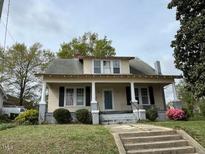 Charming two-story home featuring a covered front porch and traditional architecture at 121 W Young Ave, Henderson, NC 27536