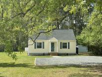 View of charming one story home with well-manicured lawn and mature trees at 1306 Ed Cook Rd, Durham, NC 27703
