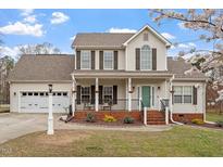 Charming two-story home with a well-manicured lawn, attached garage and inviting front porch at 15 Longwood Dr, Youngsville, NC 27596