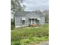 Charming single-story home featuring a gray exterior, fenced front yard, and inviting front porch at 1609 Evergreen St, Durham, NC 27703