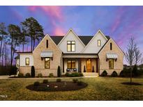Stunning exterior elevation of the home showcasing its beautiful brickwork, modern design, and lush landscaping under a vivid sky at 1629 Montvale Grant Way, Cary, NC 27519