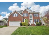 Two-story brick home with blue shutters, manicured lawn, and attached two car garage at 1903 Yellowwood Ln, Durham, NC 27712