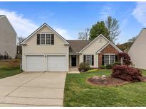 Charming home featuring well-maintained landscaping, a two-car garage, and classic architectural details at 203 Grassy Point Rd, Apex, NC 27502