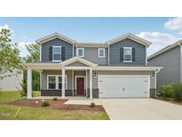 Charming two-story home featuring a two-car garage, red door, and a cozy front porch at 2202 Cherry Creek Rd, Haw River, NC 27258