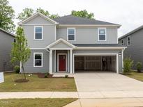 New construction two-story home featuring gray siding, a red front door, and an attached two-car garage at 2206 Cherry Creek Rd, Haw River, NC 27258
