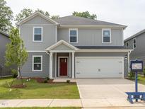 Charming two-story home with gray siding, a red front door, a manicured lawn, and an attached two-car garage at 2206 Cherry Creek Rd, Haw River, NC 27258