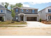 Two-story home featuring gray siding, a covered entryway, attached garage, and freshly installed lawn at 2210 Cherry Creek Rd, Haw River, NC 27258