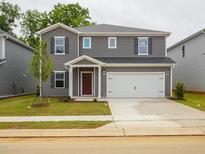 Charming two-story home with gray siding, a two-car garage, and well-maintained front yard at 2210 Cherry Creek Rd, Haw River, NC 27258