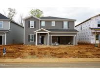 New two-story home featuring gray siding, an open garage, and a well-manicured, though unfinished, front yard at 2210 Cherry Creek Rd, Haw River, NC 27258