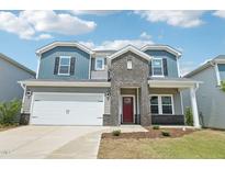 Two-story home with blue and gray siding, brick accents, a two-car garage, and a well-maintained front yard at 2211 Cherry Creek Rd, Haw River, NC 27258