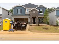 New two-story home featuring mixed siding, brick accents, an open garage and unfinished landscaping, ready for personalization at 2211 Cherry Creek Rd, Haw River, NC 27258