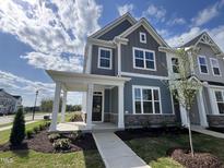 Charming two-story home with blue siding, stone accents, and a welcoming covered front porch at 2401 Whitewing Ln, Wendell, NC 27591