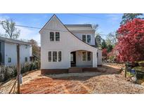 Charming two-story home featuring light-colored siding, black trim windows, and an inviting covered entryway at 2605 Hazelwood Dr, Raleigh, NC 27608