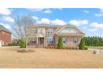 Beautiful two-story brick home featuring a manicured lawn and detailed architectural design at 2936 Turning Brook Ln, Raleigh, NC 27616