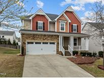 Charming two-story home featuring stone accents, a welcoming porch, and a well-manicured front yard at 3914 Glorybower Way, Apex, NC 27502