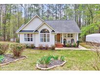 Charming single-story home with a well-manicured lawn, inviting front porch, and appealing architectural details at 413 Correy Pl, Clayton, NC 27520