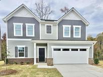 Charming two-story home with a two-car garage and attractive gray and white siding at 829 Kenyon Spring Dr, Zebulon, NC 27597