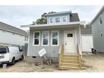 Charming gray home showcasing a welcoming front door and wood stairs, plus bright windows at 905 Linwood Ave, Durham, NC 27701