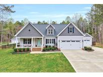 Charming home featuring gray siding, a well-manicured lawn, and a welcoming front porch at 1165 Shonele Ln, Stem, NC 27581