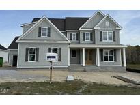 Beautiful two-story home with gray siding, dark shutters, covered porch, and architectural shingles at 125 Summerlin Dr, Clayton, NC 27527