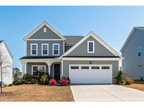 Charming two-story home with gray siding, black roof, manicured lawn, and a two-car garage at 139 Pronghorn Deer Ct, Garner, NC 27529