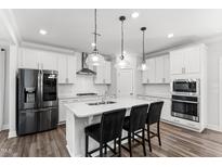 Modern kitchen boasts stainless steel appliances, a spacious island with seating, and stylish pendant lighting at 139 Pronghorn Deer Ct, Garner, NC 27529
