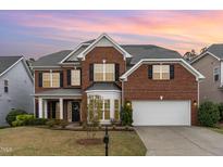 Charming two-story brick home with a well-manicured lawn and attached two-car garage at 1607 Willowcrest Rd, Durham, NC 27703