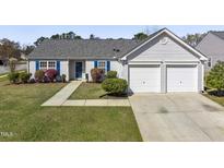 Charming single-story home featuring a well-maintained lawn and a two-car attached garage at 1905 Maple Sugar Ln, Fuquay Varina, NC 27526