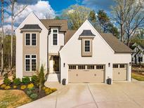 Stunning home featuring a brick facade, two-car garage, and professionally landscaped front yard at 215 Bonterra Way, Chapel Hill, NC 27516