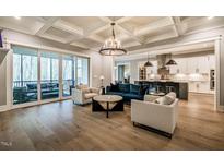 Bright living room boasts an open floor plan, stylish furniture, and easy access to the screened porch at 215 Bonterra Way, Chapel Hill, NC 27516