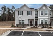 Charming townhome exterior featuring gray siding, stone accents, and well-manicured landscaping at 2456 Tonoloway Dr, Raleigh, NC 27610