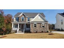 Beautiful two-story home with stone accents, a covered front porch, and manicured landscaping for a welcoming curb appeal at 263 Gilliland Rd, Siler City, NC 27344